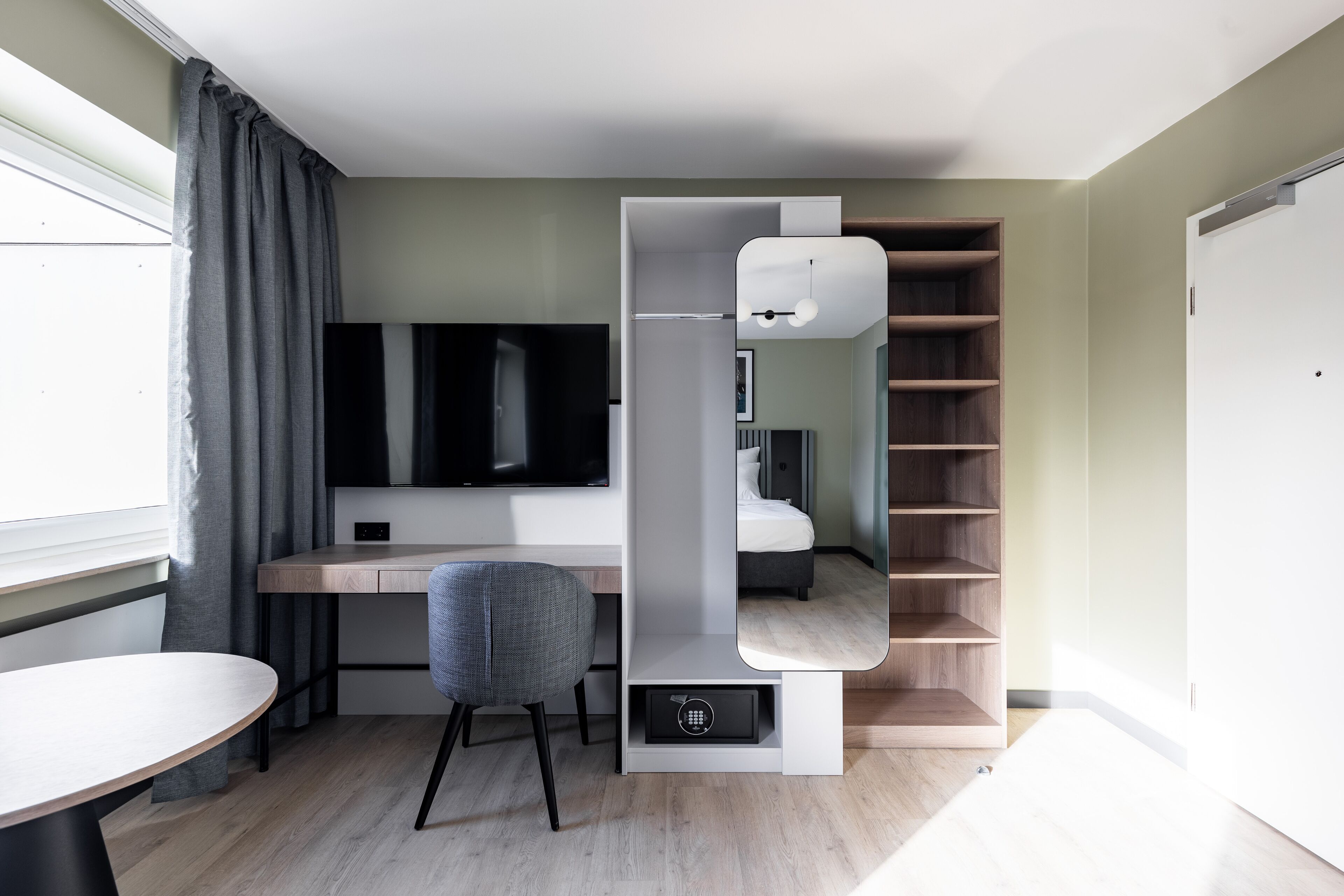 Una habitación moderna y funcional con escritorio, silla y estanterías empotradas.