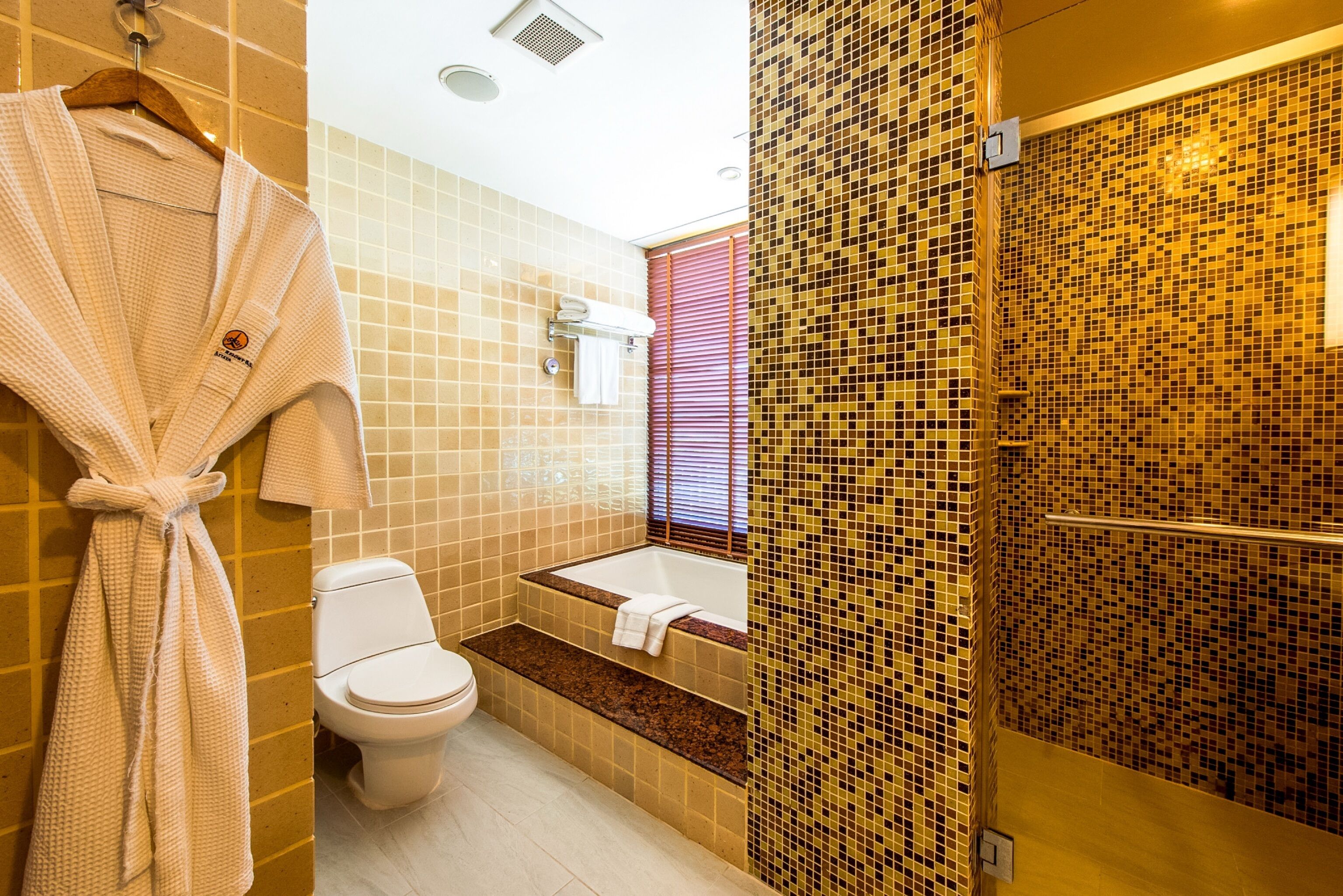 A bathroom with a toilet, bathtub, and shower.