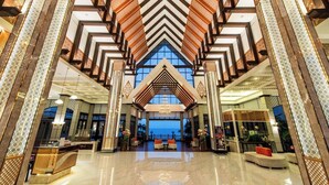 A spacious lobby with a high ceiling, a reception desk, and a view of the ocean. - Garden Cliff Resort and Spa (Pattaya)
