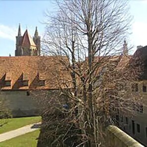 A historic building with a prominent tower and a well-maintained lawn. - Burg-Hotel Relais du Silence (Rothenburg ob der Tauber)