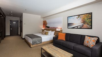 Une chambre d’hôtel avec un lit, un canapé, une table basse et deux tableaux accrochés au mur.