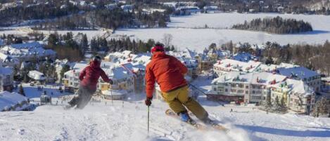 A ski resort with snow-covered buildings and a clear view of the surrounding mountains.