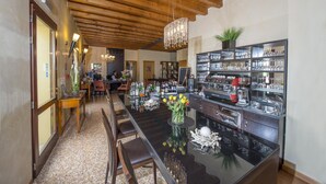 A spacious kitchen with a central island, wooden ceiling beams, and a chandelier. - Hotel Venice Resort Airport (Mestre)