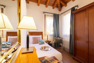 Una habitación de hotel con una cama de madera, una computadora portátil, una bandeja con desayuno y un espejo grande.