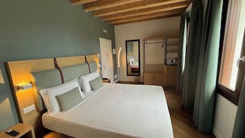 Habitación Deluxe | Edredón, minibar, caja de seguridad en la habitación y escritorio