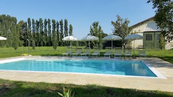 Una piscina al aire libre, tumbonas