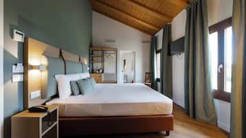 Un dormitorio con techo de madera, una cama, mesitas de noche, un armario y un televisor.