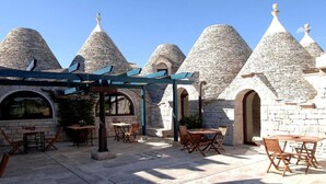 Un patio con edificios de piedra y mobiliario exterior.