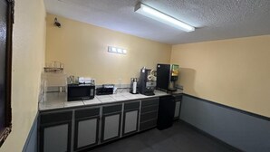 A small kitchenette with a microwave, coffee maker, and a refrigerator. - Residential Suites Warrensburg by Hotel O US 50 (Knob Noster)