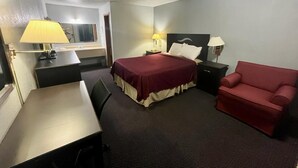 A hotel room with a bed, a desk, a chair, and two bedside tables with lamps. - Residential Suites Warrensburg by Hotel O US 50 (Knob Noster)