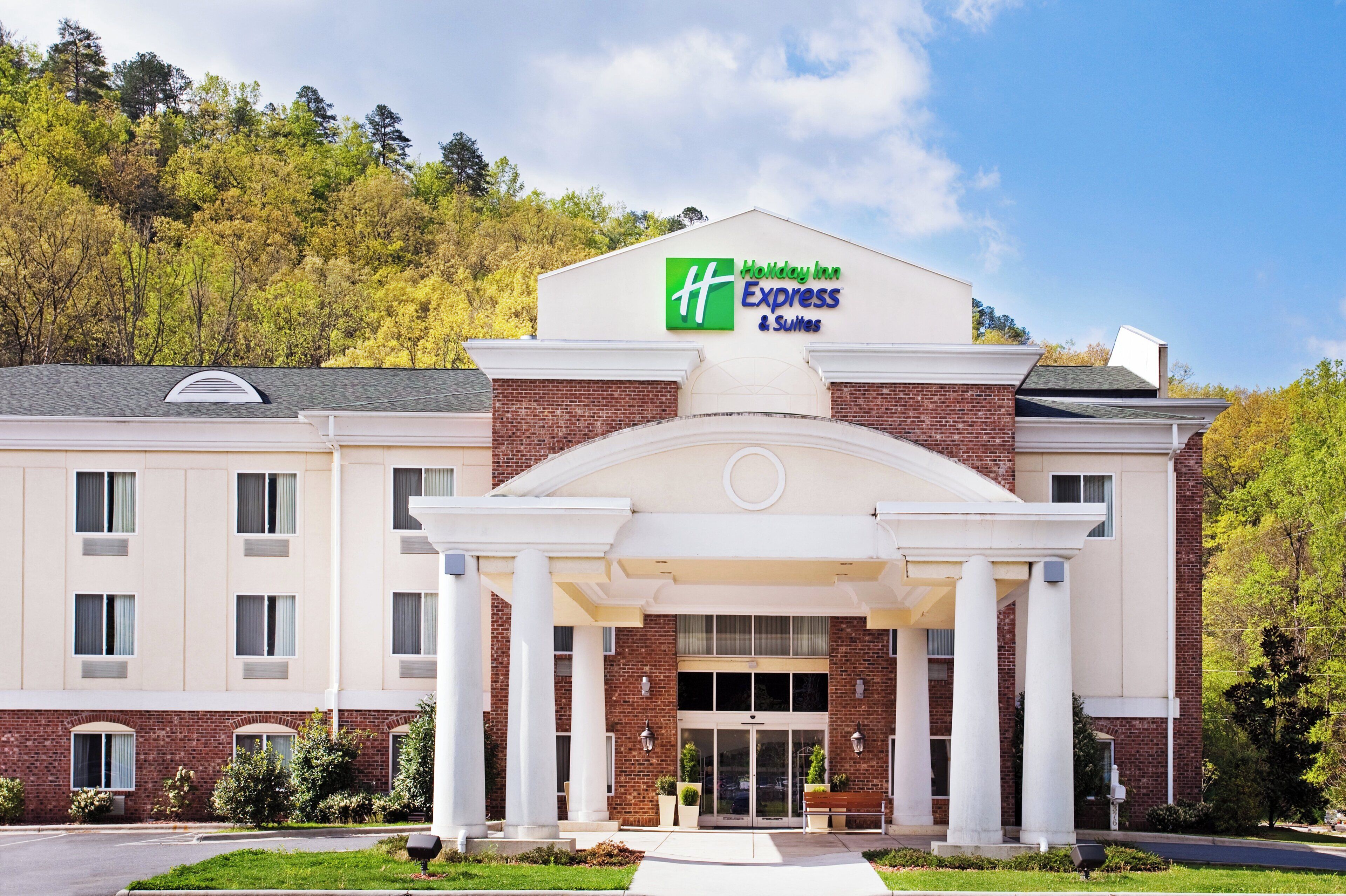 Edificio de Holiday Inn Express & Suites con fachada de ladrillo, amplia entrada con columnas y un letrero sobre la entrada.