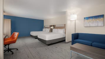 Une chambre d’hôtel avec un lit, un bureau, une chaise et un canapé.
