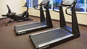 Un gimnasio con cintas de correr y una máquina elíptica.