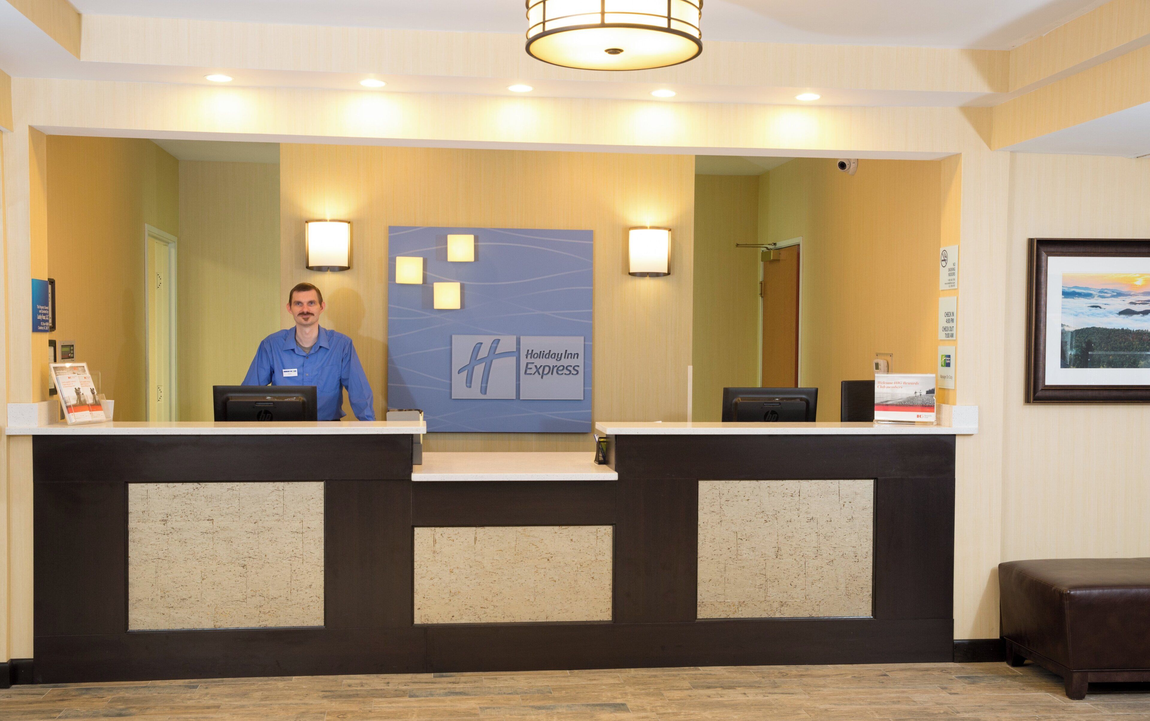 A reception desk with a Holiday Inn Express sign, a computer, and a framed picture on the wall.