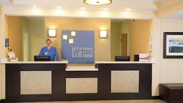 A reception desk with a Holiday Inn Express sign, a computer, and a framed picture on the wall.