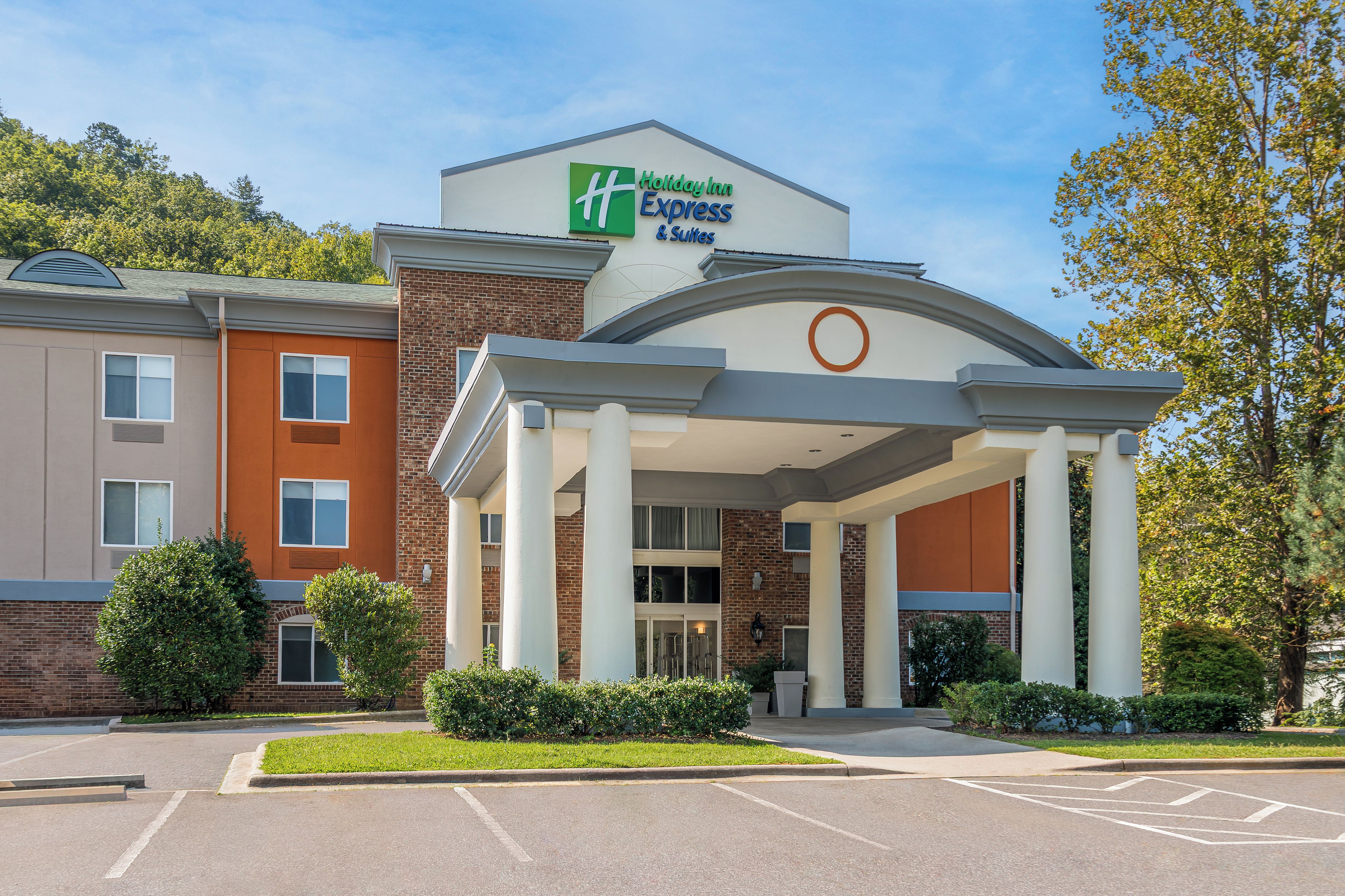 Un hotel Holiday Inn Express & Suites con fachada de ladrillo, amplia entrada y aparcamiento.