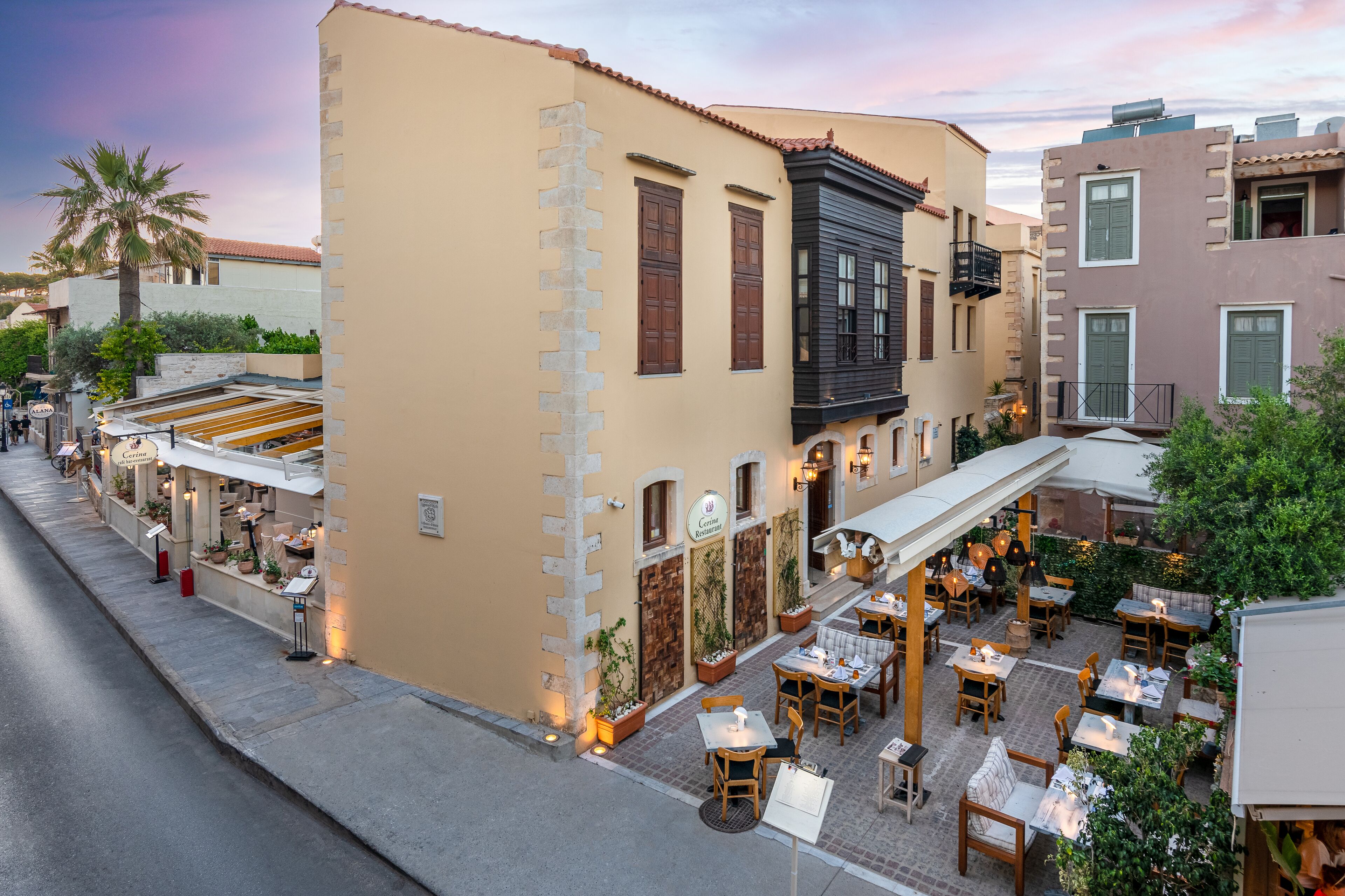 Un restaurante con terraza al aire libre y vistas a la calle.