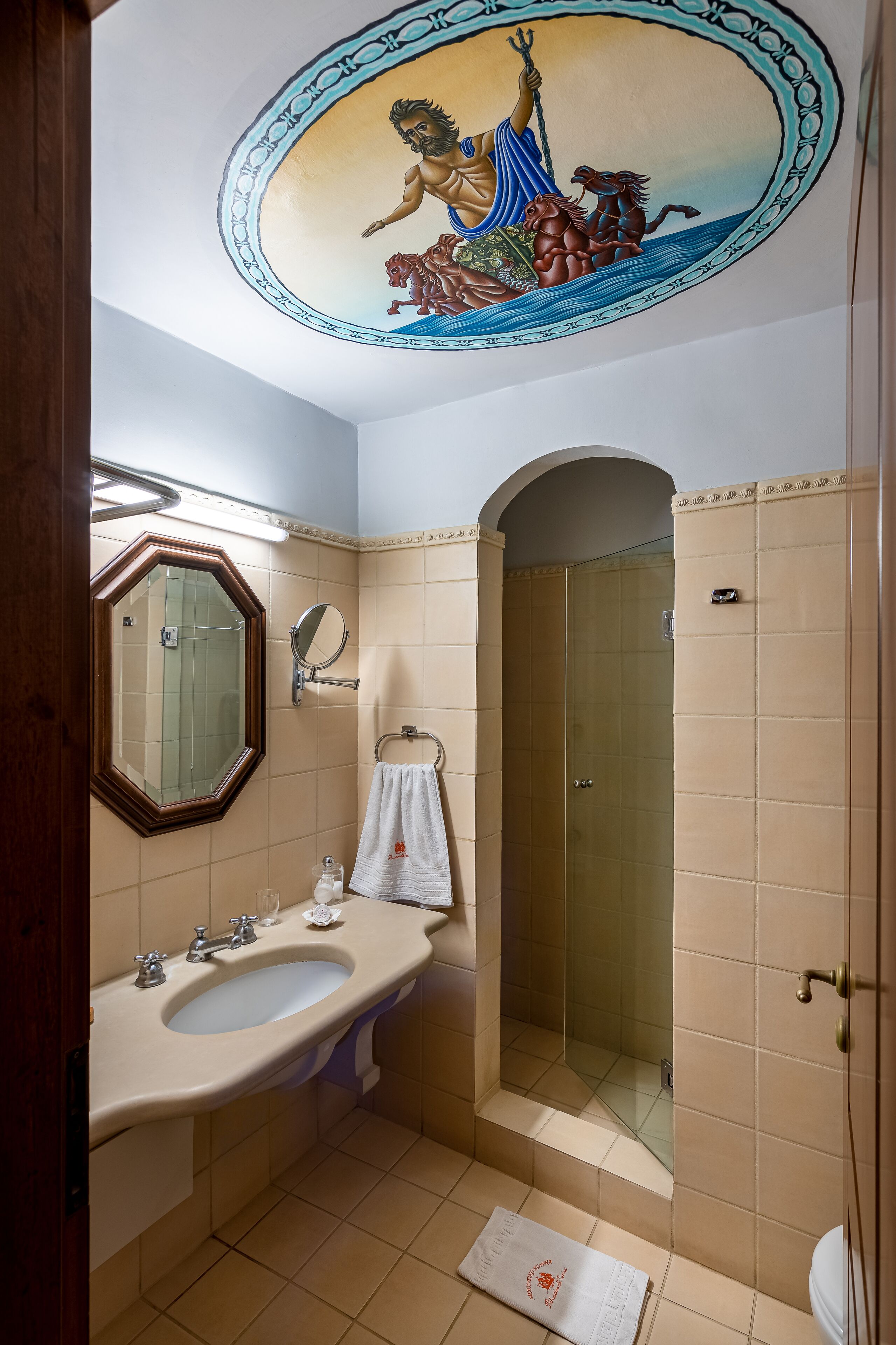 A bathroom with a large mirror, sink, and shower.