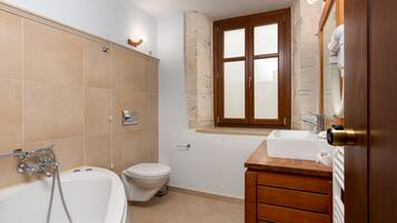 Un baño con bañera, inodoro y lavamanos.