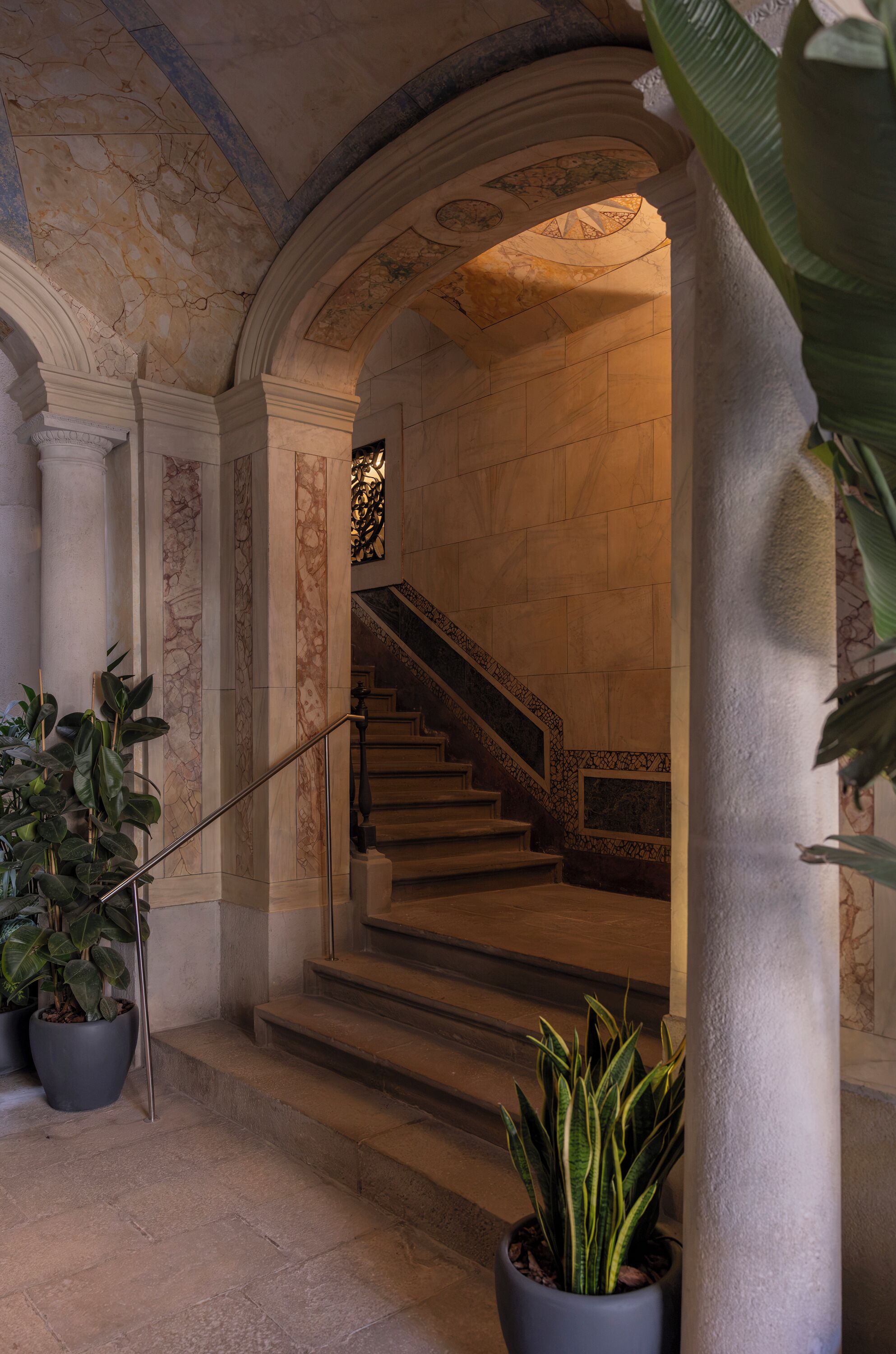 A grand staircase with marble steps and a balustrade, leading to an upper floor.