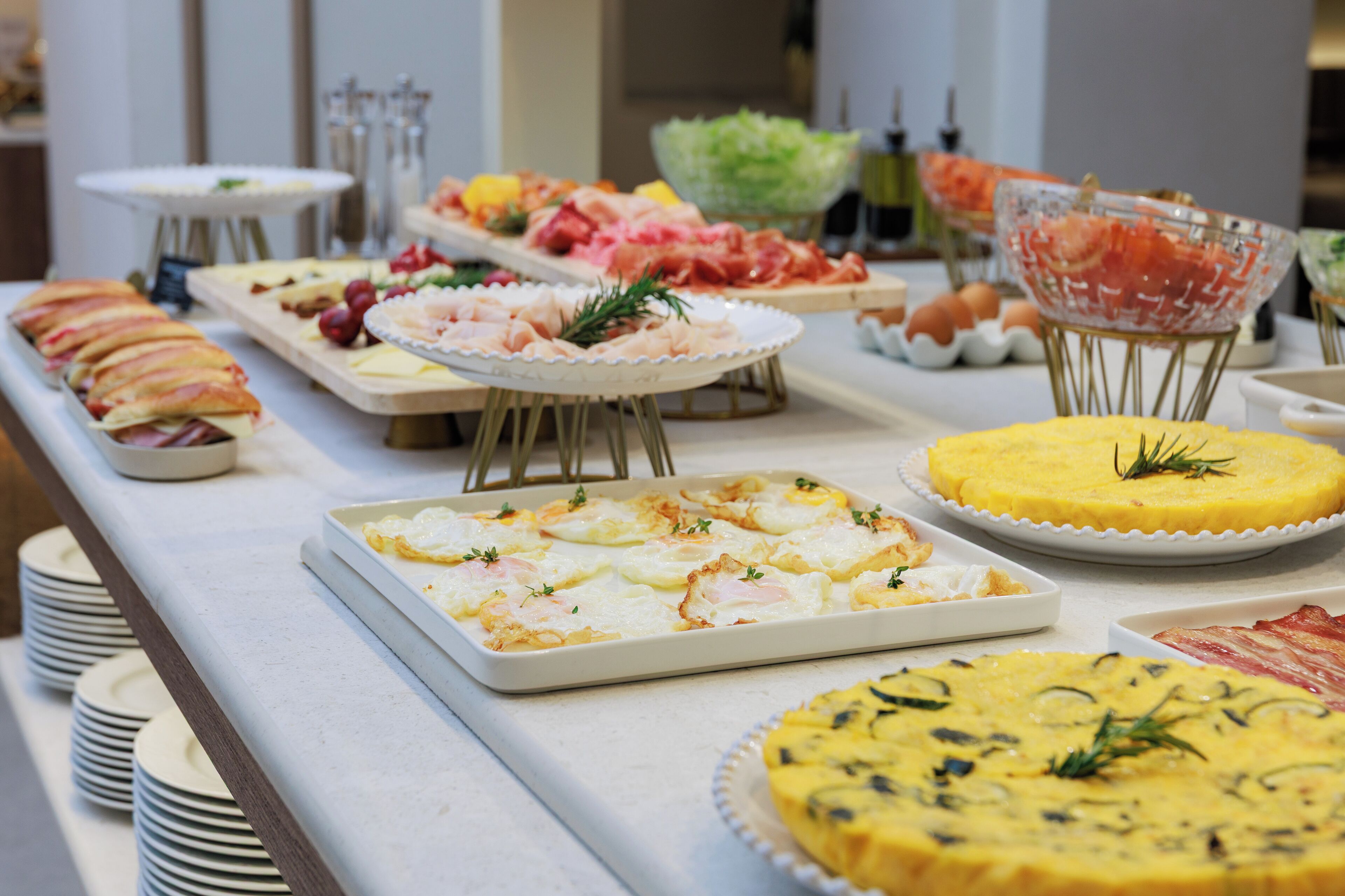 A buffet with various dishes including eggs, meats, and salads.