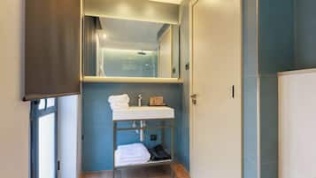 Een moderne badkamer met een ingebouwd wastafelmeubel, een spiegel erboven en een handdoekrek.
