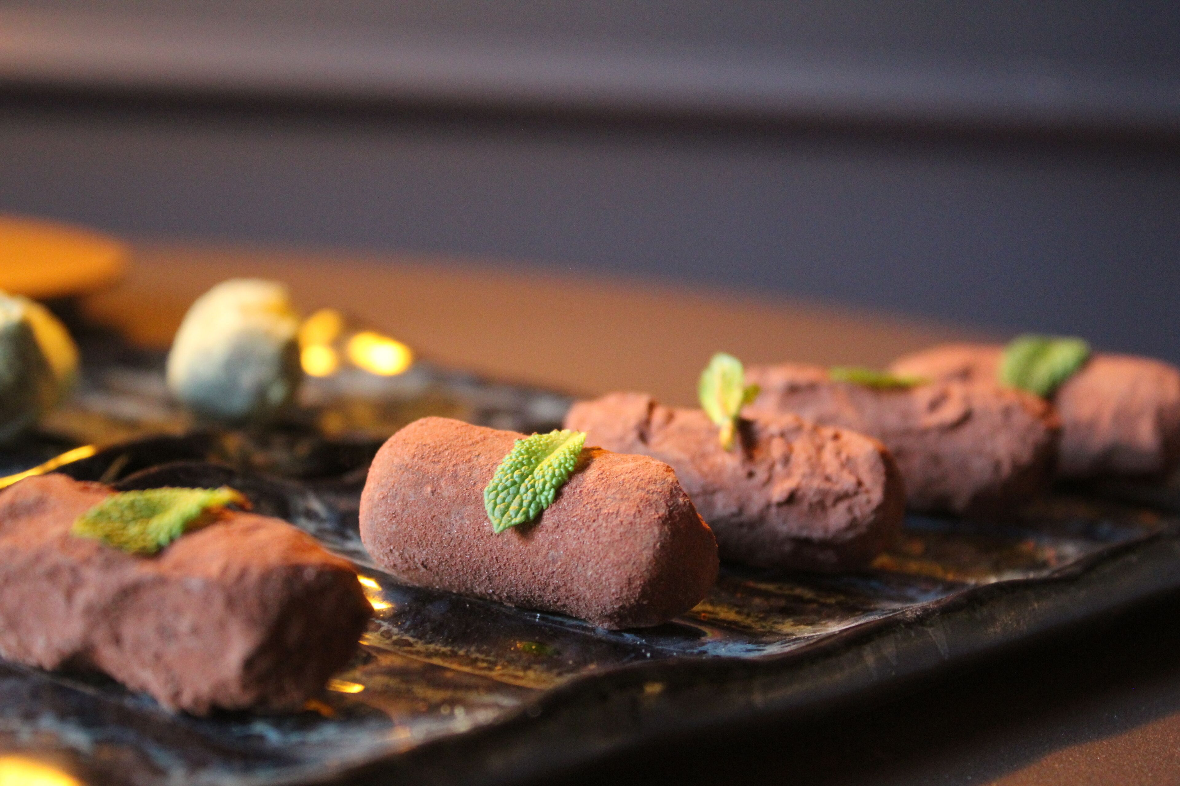 Un plato de postres con rollitos de chocolate y hojas de menta.
