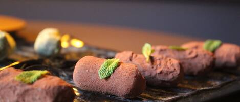 Un plato de postres con rollitos de chocolate y hojas de menta.