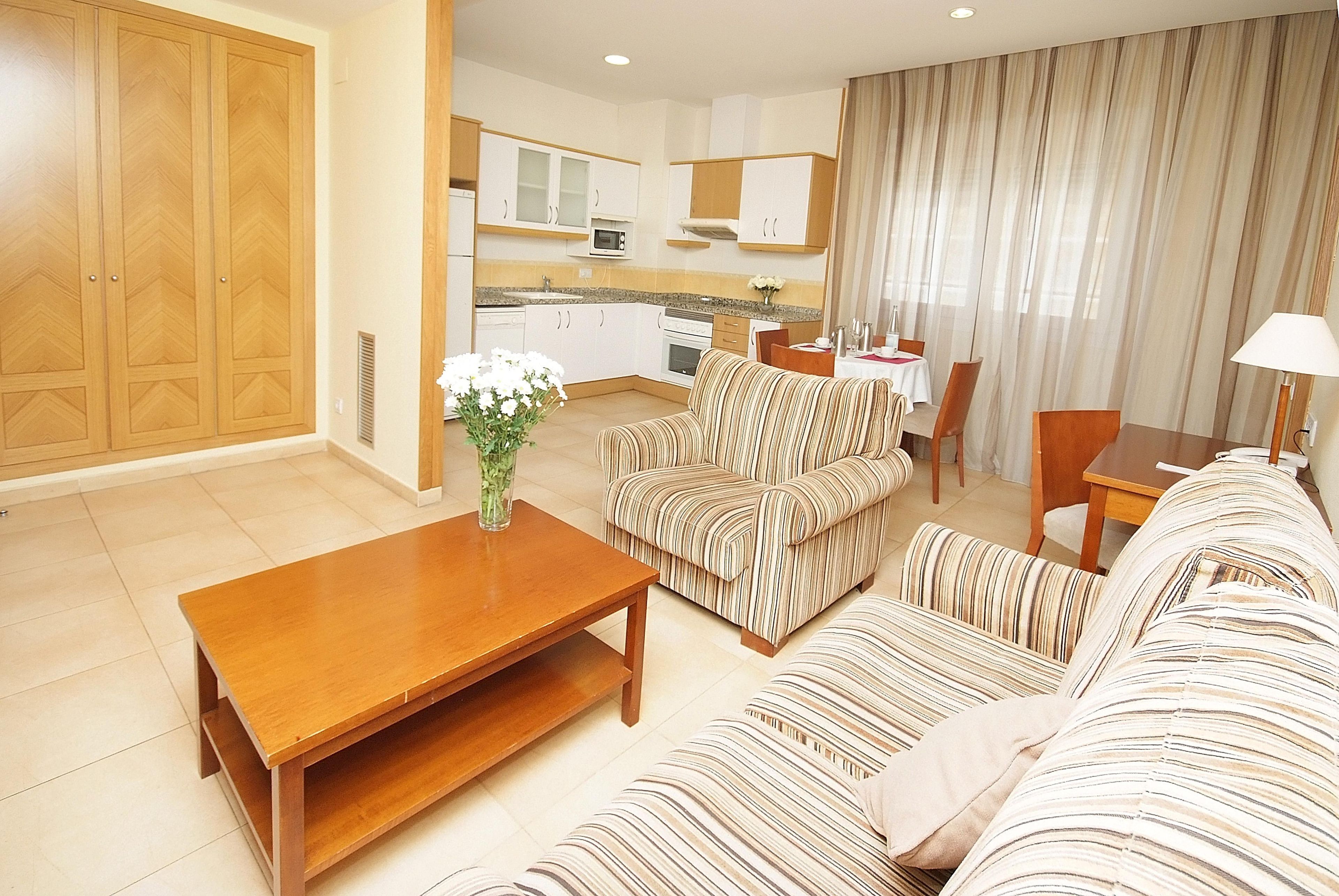 Una sala de estar con sofá, una mesa de centro y un comedor con mesa y sillas.