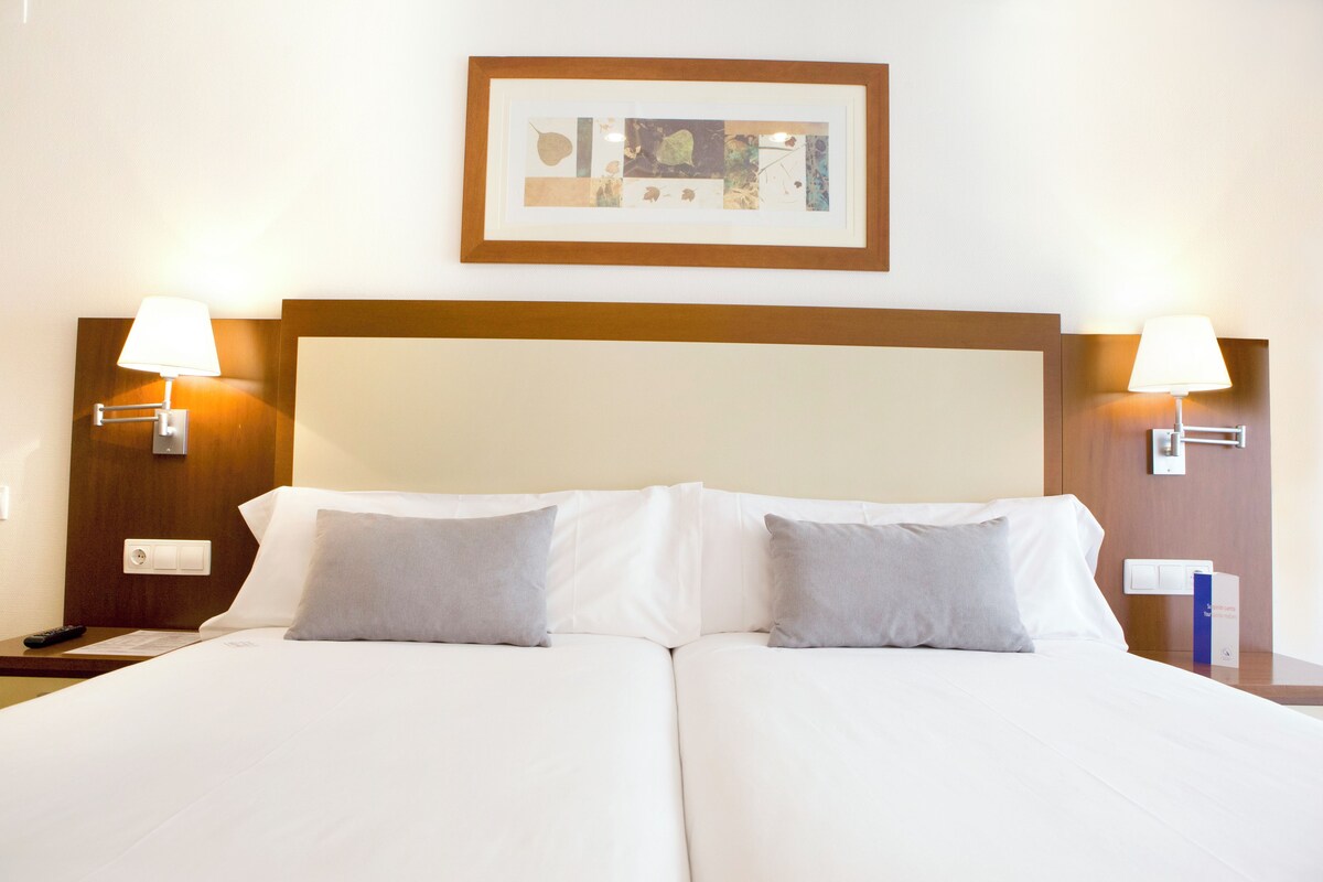 أغطية فراش متميزة وخزنة داخل الغرفة ومكتب وستائر تعتيم