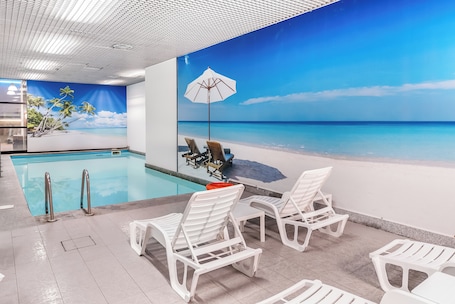 Una piscina techada, sillones reclinables de piscina. Abacus Hotel