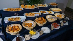 Ein reichhaltiges Buffet mit verschiedenen Speisen, darunter Brot, Gebäck und Beilagen.