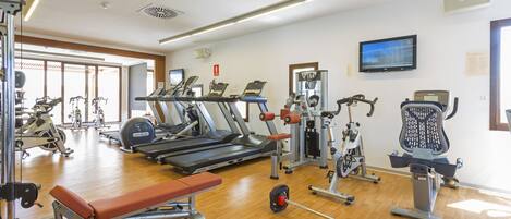 A gym with treadmills, weight machines, and a bench.