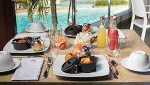 A breakfast table with various dishes, drinks, and utensils.