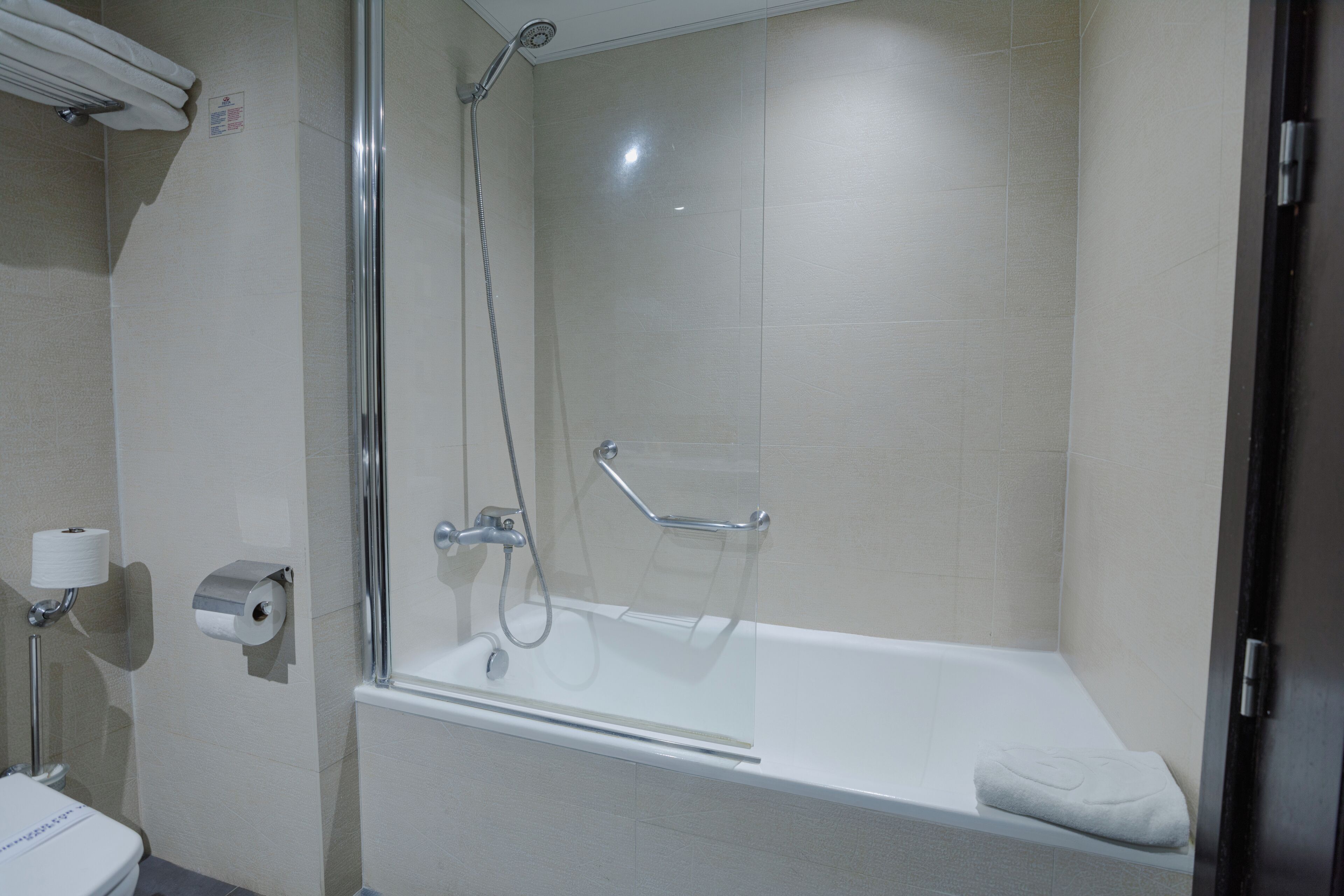 Ein modernes Badezimmer mit einer Duschkabine, einer weißen Badewanne und einem WC.