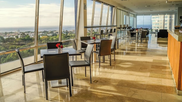 A modern restaurant with large windows offering a city view.