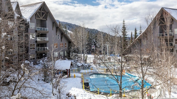 Un complexe hôtelier doté de grands bâtiments, d’une piscine et offrant un paysage enneigé.