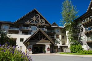 Experience the grandeur of this hotel's stone facade and spacious balconies, offering a tranquil retreat with potted plants and a welcoming entrance.