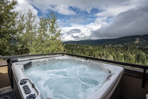 Ein Whirlpool mit Blick auf Wald und Berge.