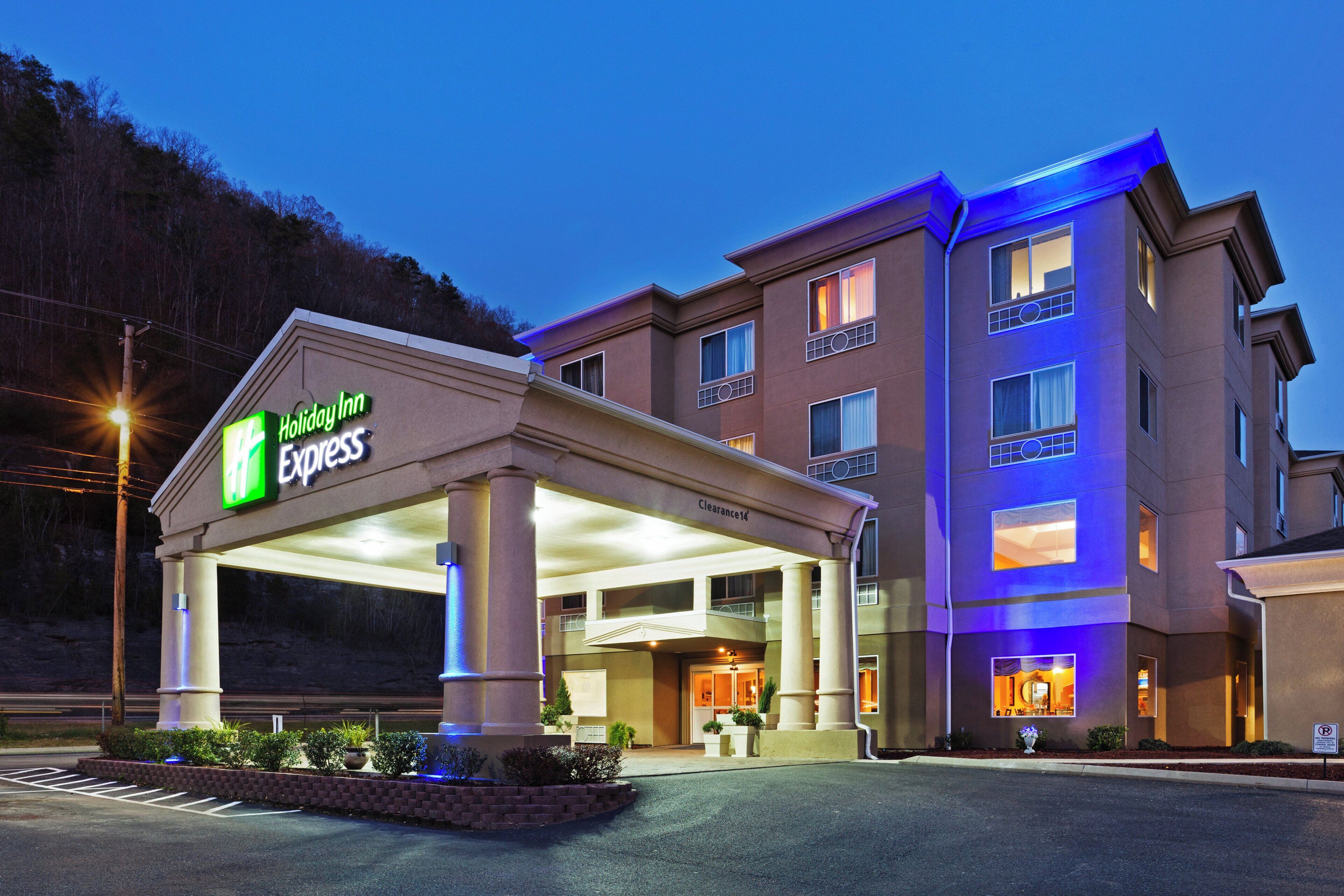 Een Holiday Inn Express gebouw met een overdekte ingang, meerdere verdiepingen en een parkeerplaats.