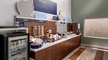 A breakfast bar with a sign reading "EXPRESS START BREAKFAST" and sections labeled "FRUIT" and "CEREAL".