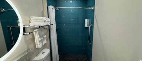 A compact bathroom with a toilet, sink, and shower.