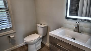 Un baño con inodoro, lavabo y ventana.