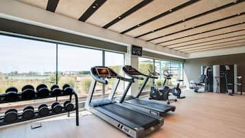 Un gimnasio moderno con cintas de correr, mancuernas y equipo de ejercicio.