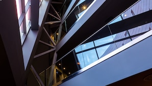 A multi-level interior with glass railings and a geometric ceiling design. - Barcelona Airport Hotel (El Prat de Llobregat)