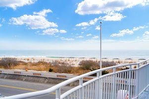 A coastal road with benches and a beach in the background.