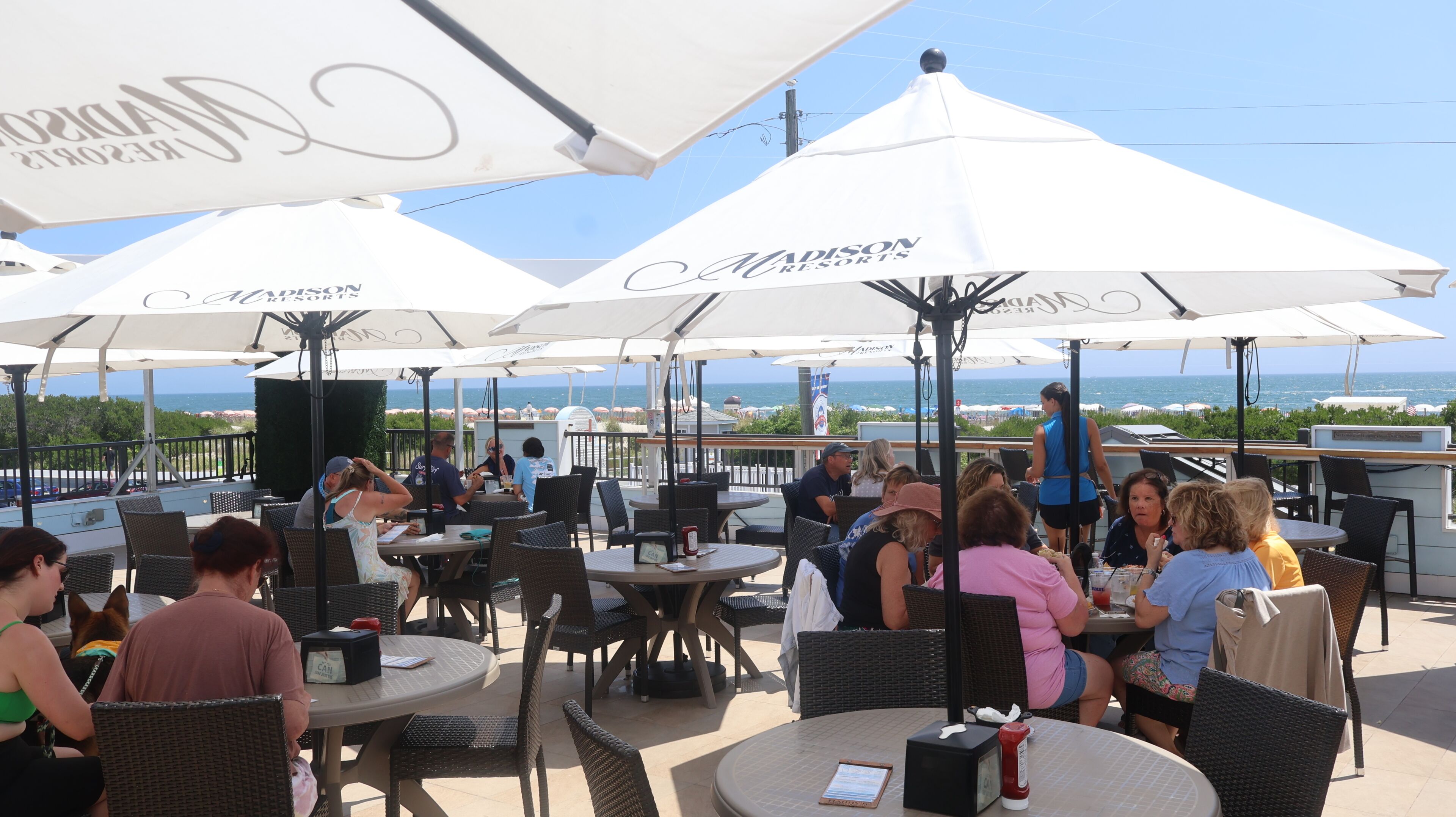 Espace extérieur aménagé avec des parasols, des tables et des chaises, dans un complexe hôtelier.