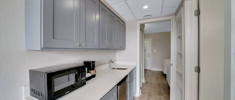 Una cocina moderna con gabinetes grises, microondas y cafetera.