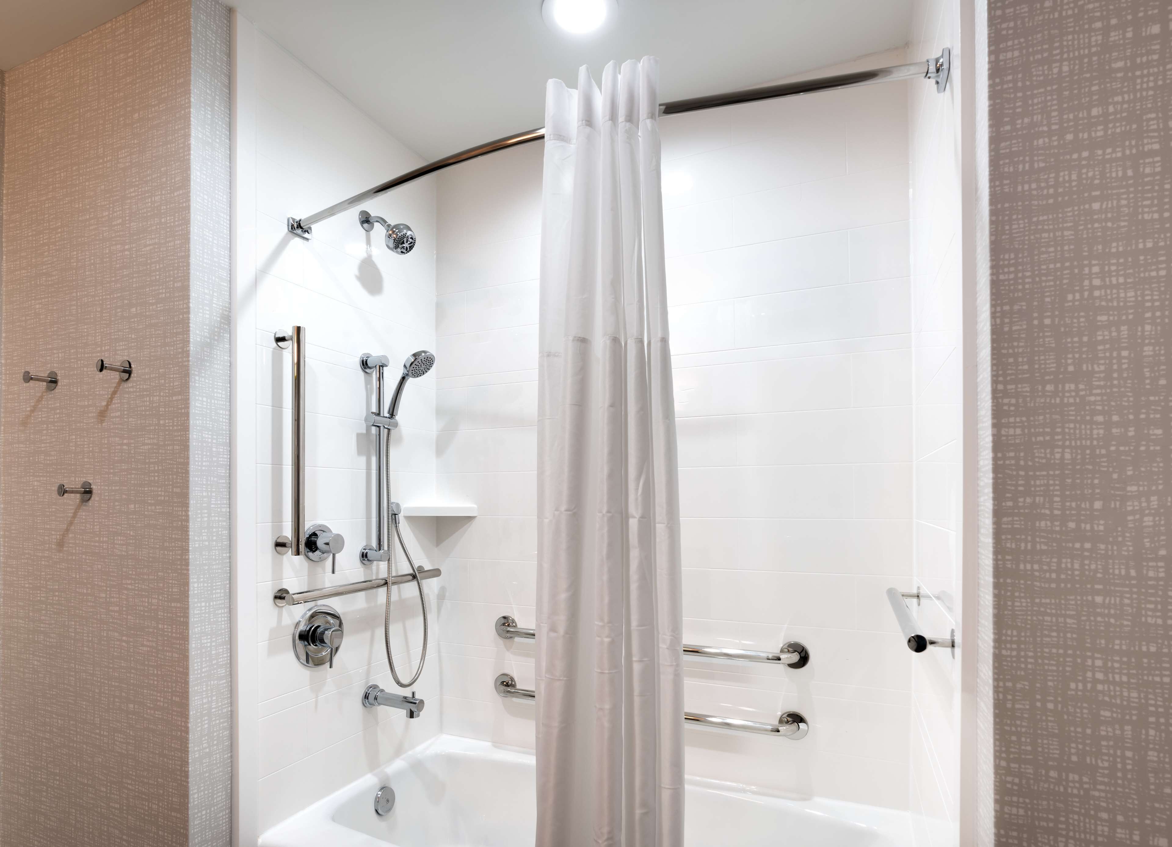 A modern bathroom with a bathtub, shower, and toilet.