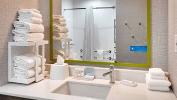 A modern bathroom with a sink, mirror, and towel racks.